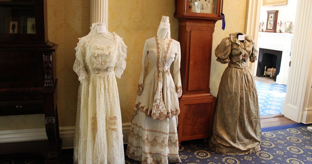 Elegant vintage dresses showcased in a historic Lancaster house room, featuring antique interior decor.