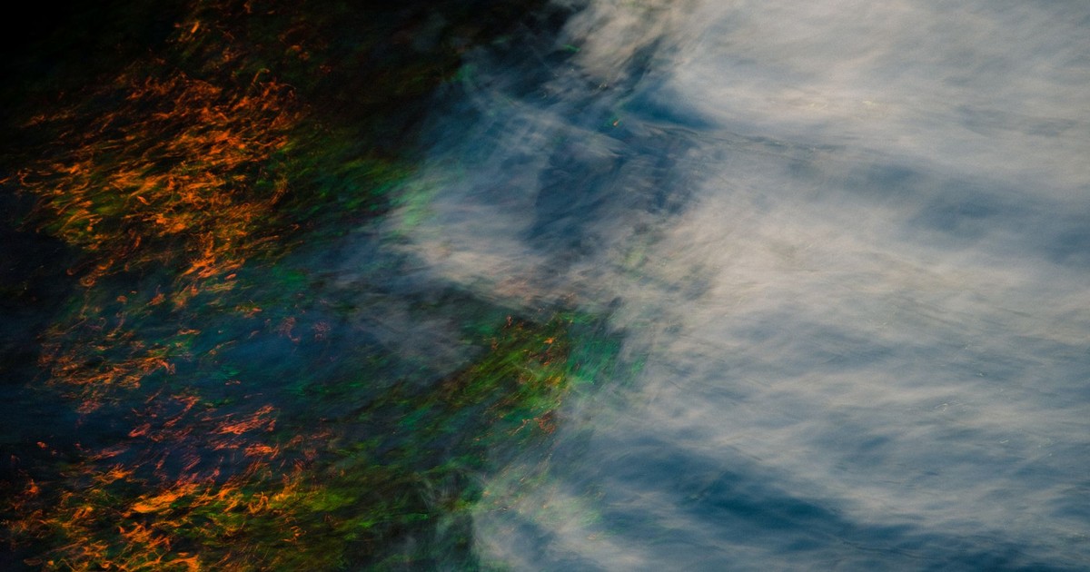 Artistic abstract image of colorful reflections and ripples on a water surface, creating a vibrant visual effect.