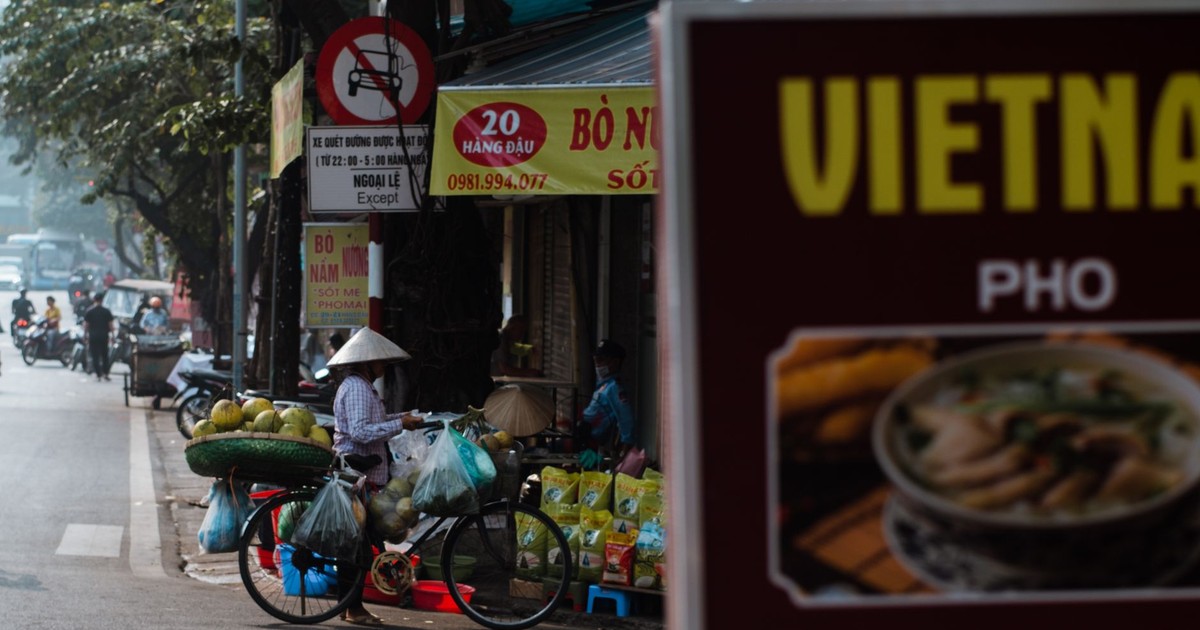 A vibrant scene of a Vietnamese street vendor with produce-laden bicycle in Hanoi.