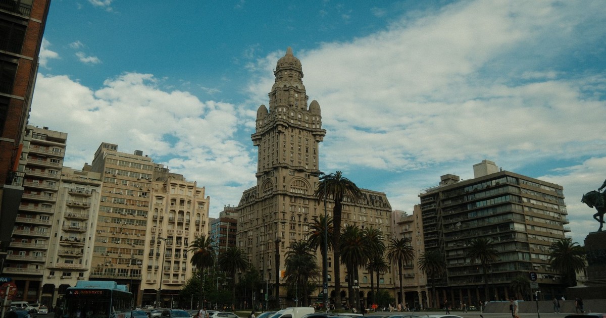 Street view of Salvo Palace in Montevideo with blue sky and city traffic.