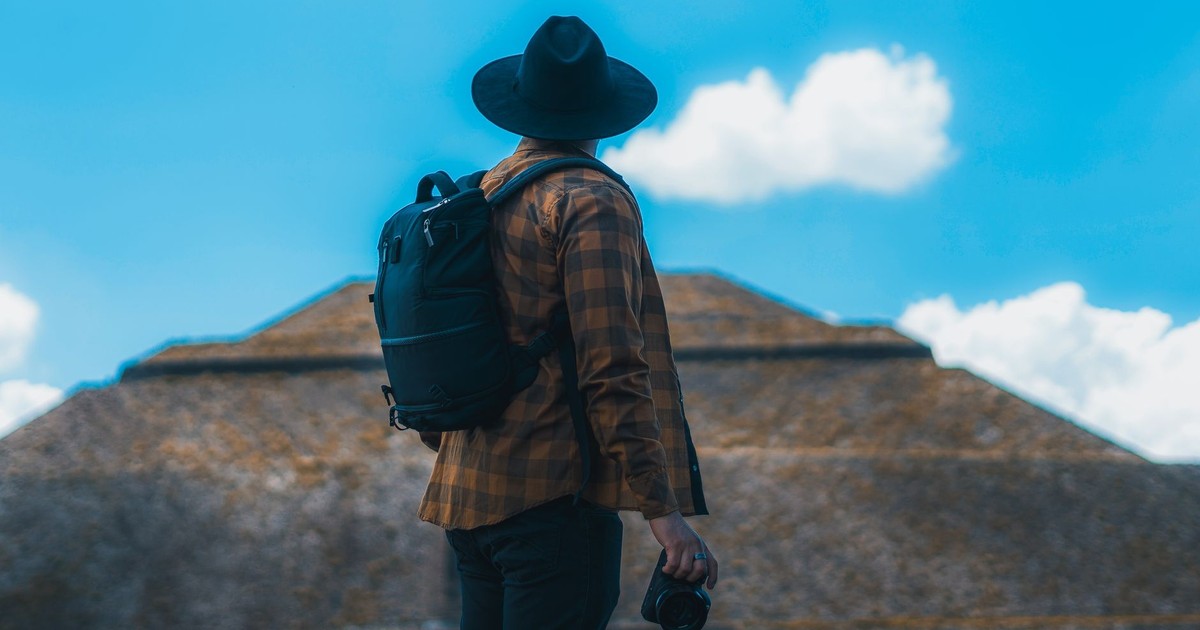 Man with a backpack and camera exploring the pyramids of Teotihuacan, Mexico.