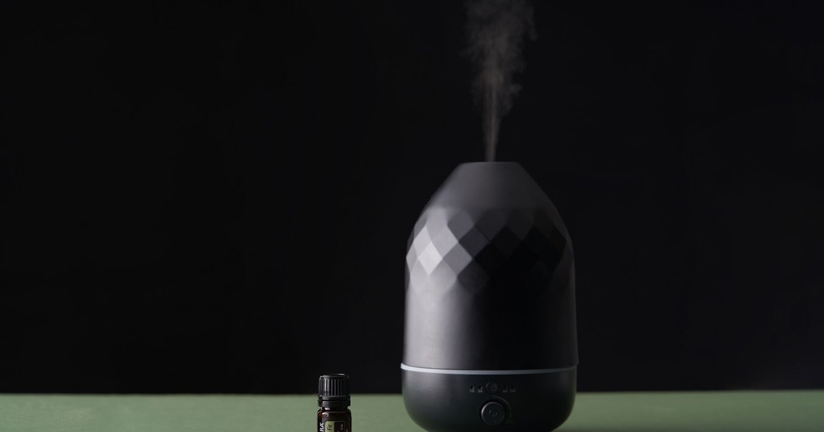A stylish essential oil diffuser emits vapor, creating a serene atmosphere with a focus on well-being.
