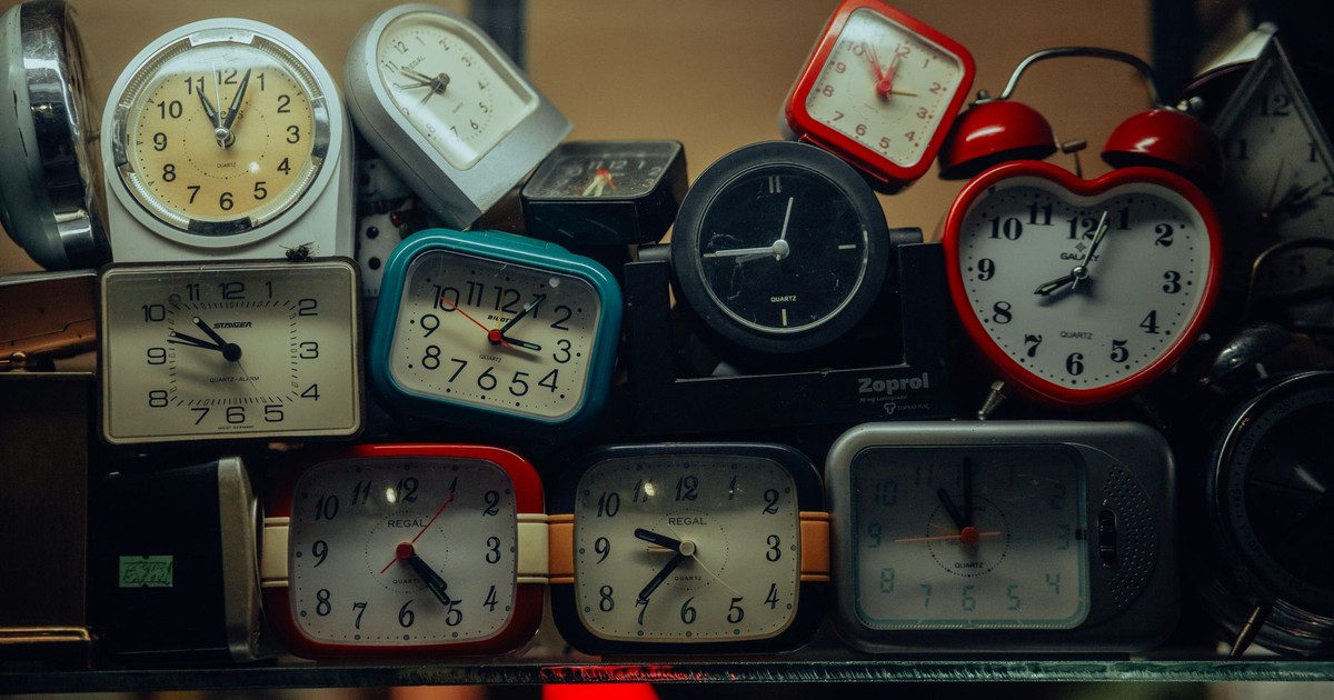 A collection of vintage alarm clocks stacked together, showcasing diverse designs and styles.