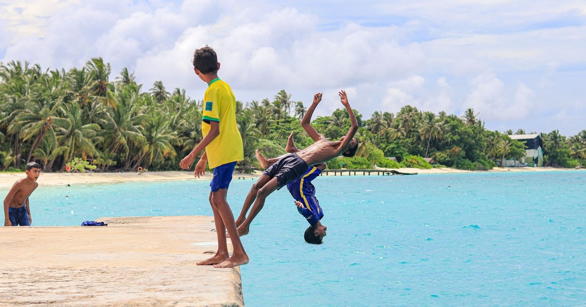 Boys playing by the turquoise waters of Maldives, enjoying a summer beach day.