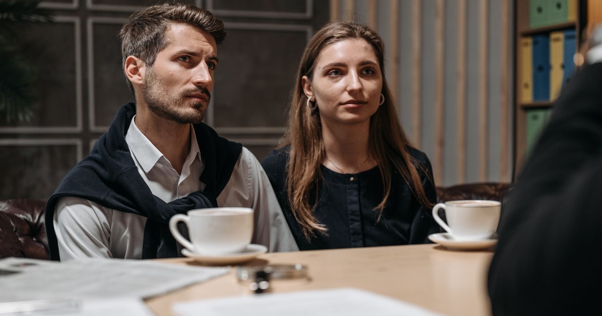 Business meeting with a couple engaging with a consultant in a modern office setting.