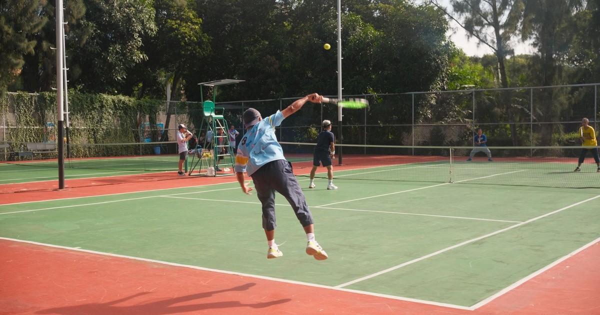 Dynamic tennis match on an outdoor court with players in motion, showcasing athleticism and teamwork.