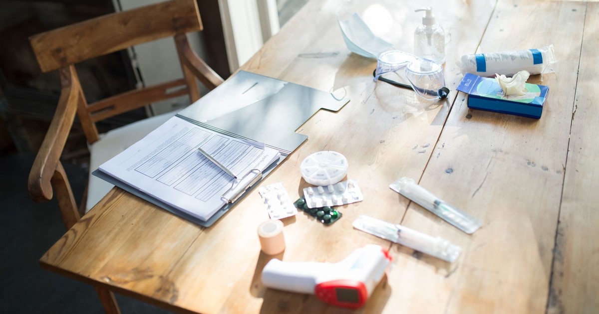 A spread of medical supplies and COVID-19 essentials on a sunlit wooden table.