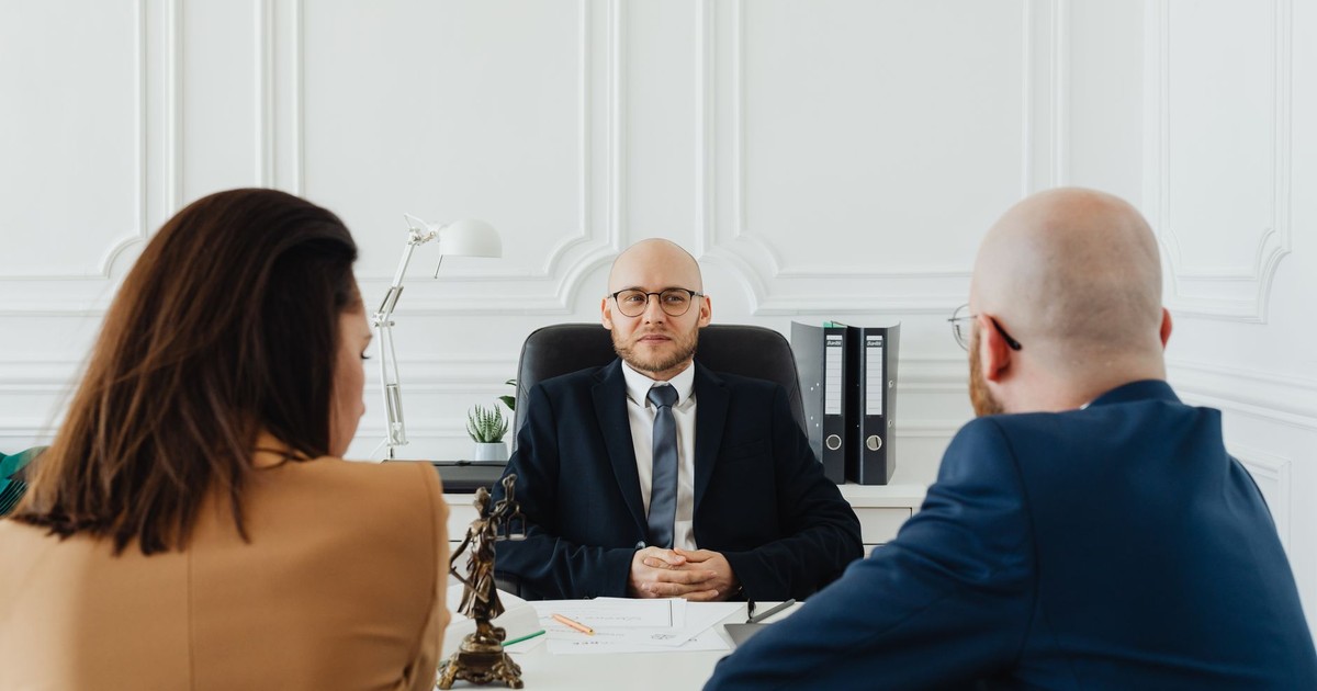 Lawyer meeting with clients in a formal office setting for legal consultation.
