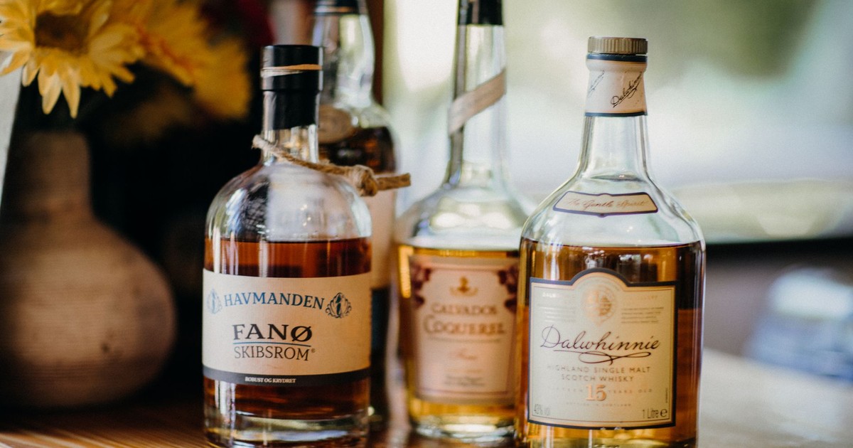 Close-up of premium whiskey and rum bottles displayed on a wooden surface.