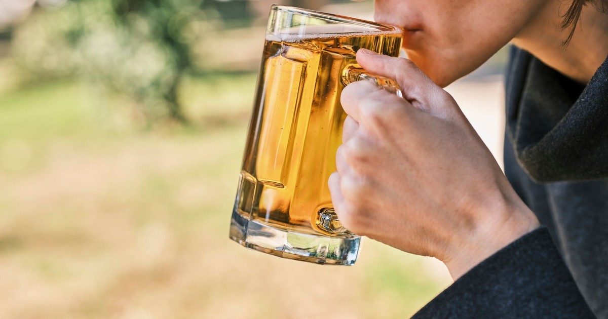 A person enjoying a refreshing beer outdoors on a sunny day.