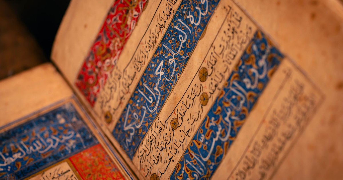 Detailed view of an ancient illuminated manuscript with Arabic script and intricate designs.