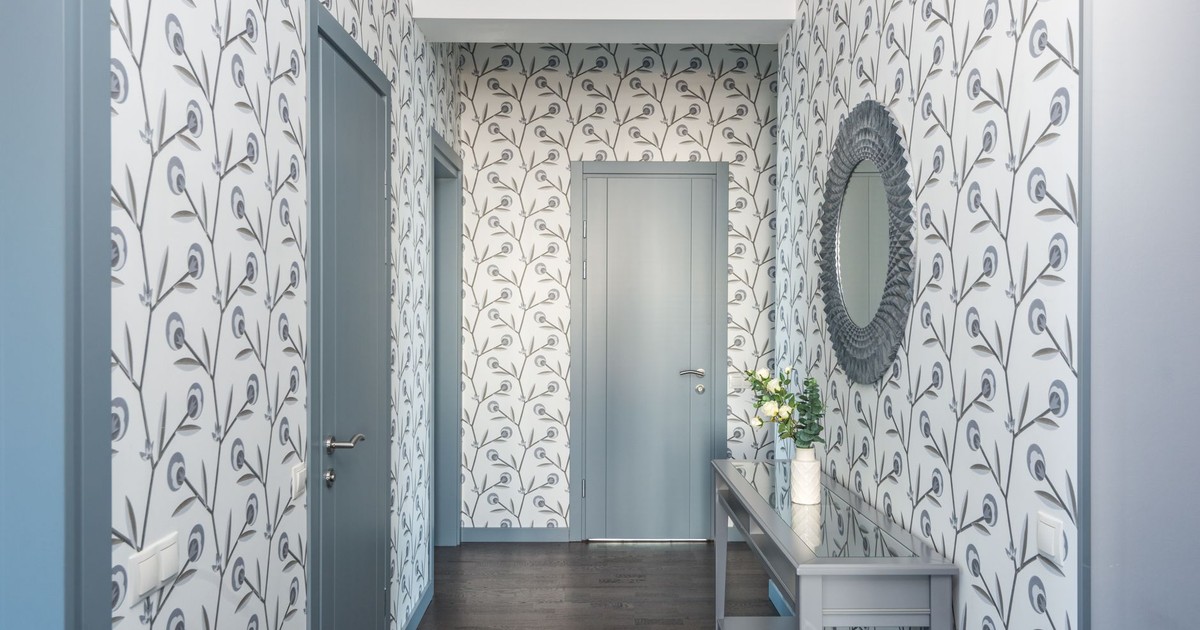 A stylish hallway featuring floral wallpaper, a console table, and a decorative mirror.