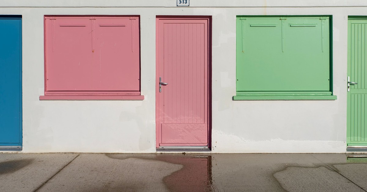 Vibrant blue, pink, and green garage doors on a city street wall, offering artistic contrast.