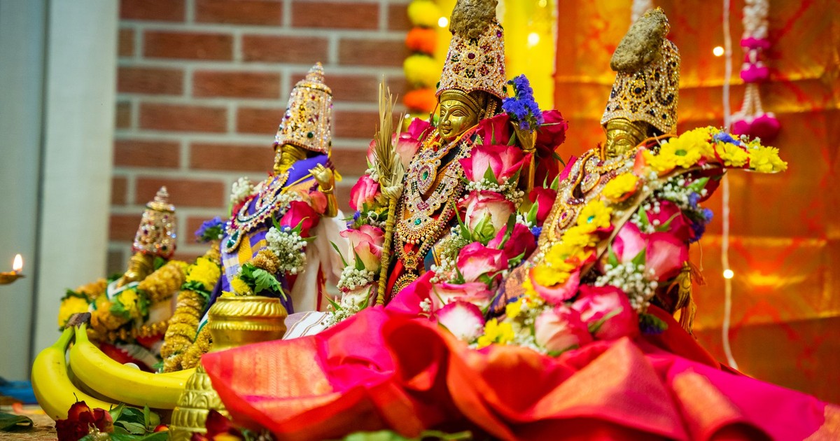 Detailed depiction of Hindu deities adorned with colorful flowers, symbolizing festivity and spirituality.