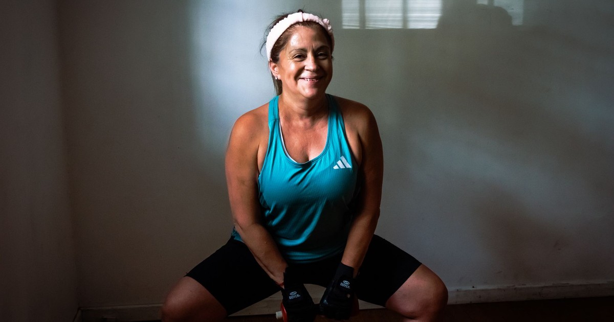 Healthy woman working out indoors with dumbbells, promoting fitness and strength.