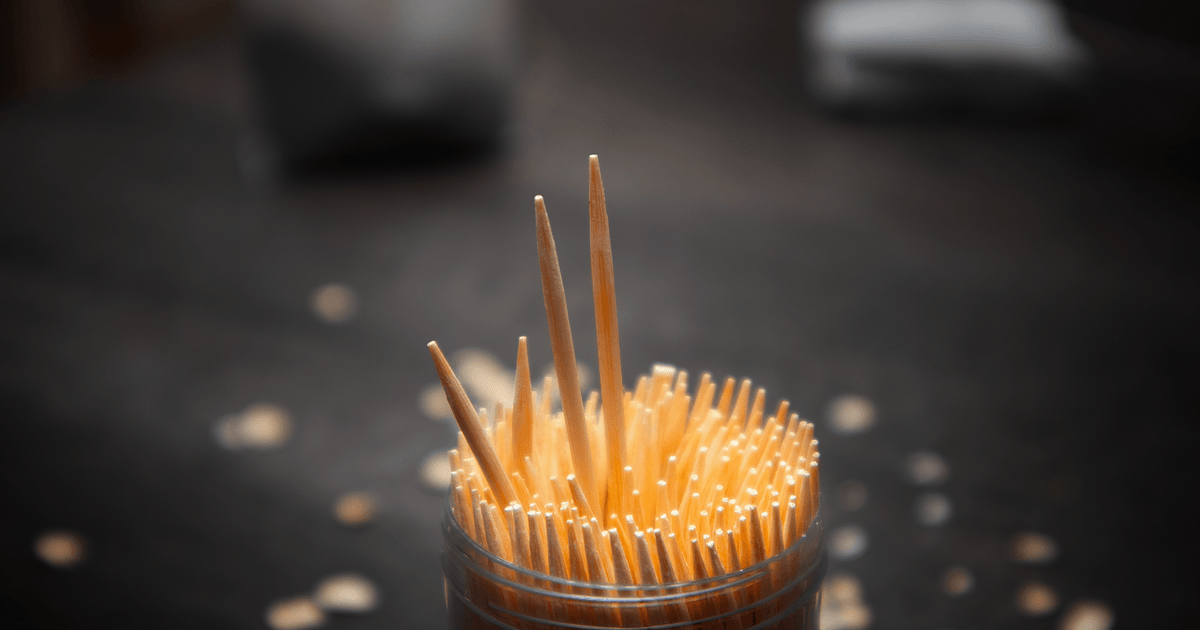A detailed shot of toothpicks in a jar on a dark surface, ideal for kitchen or tabletop themes.