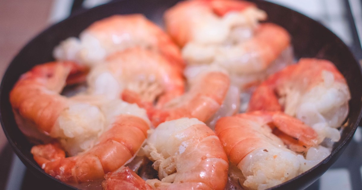 Delicious close-up of prawns sizzling in a frying pan, perfect for seafood lovers.