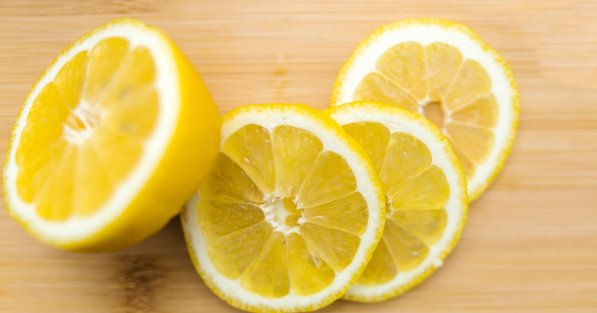 Fresh sliced lemons arranged on a wooden surface, showcasing vibrant citrus colors.