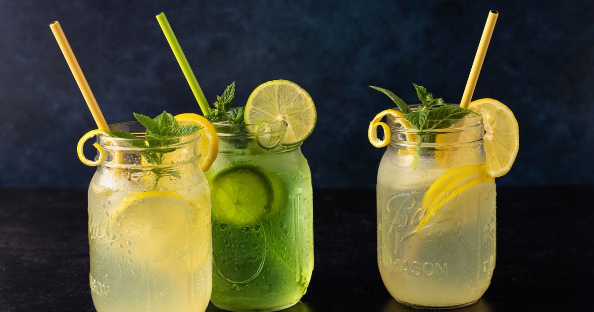Three mason jars filled with lemon and lime refreshment garnished with mint.