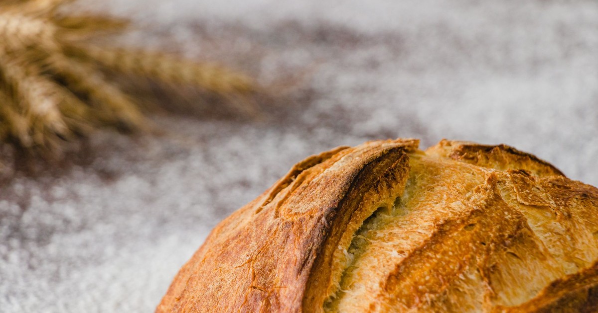 Freshly baked crusty bread with flour and wheat stalks for a rustic look.