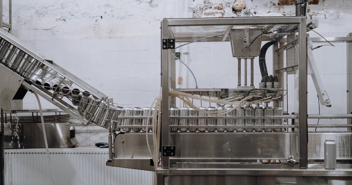 Automated beverage can packaging in a modern factory setting.