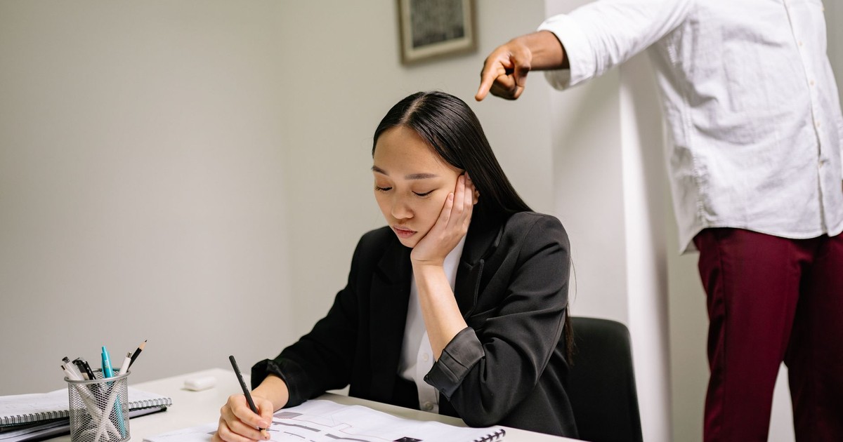 An unhappy employee experiencing workplace bullying, depicted by finger pointing in an office setting.