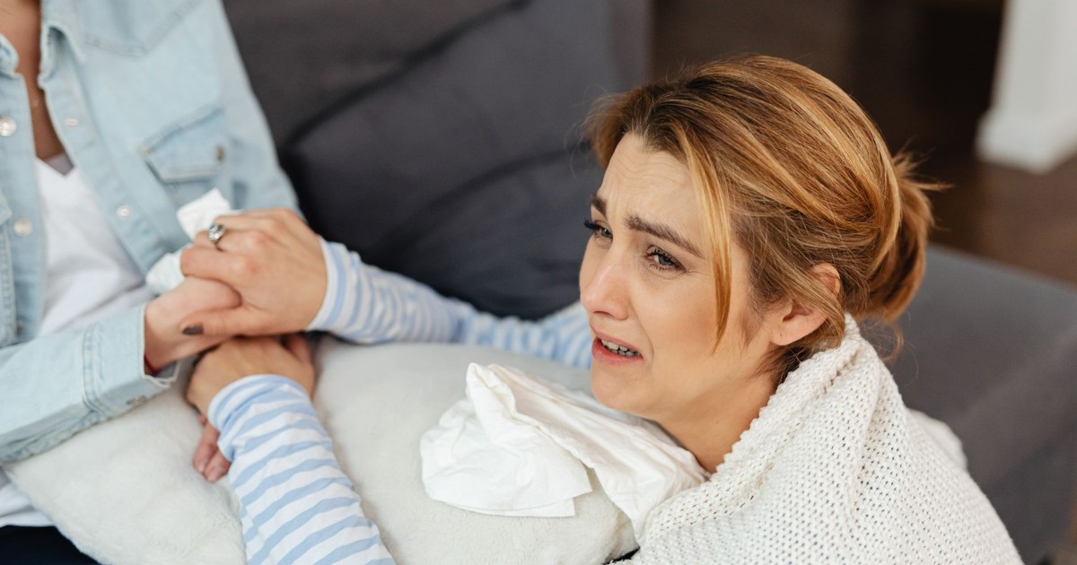 A crying woman is comforted by a friend, showcasing emotional support and empathy.