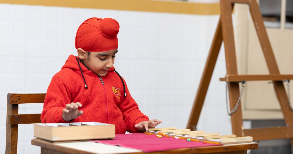 Young child in a classroom setting, engaging with an educational toy, promoting learning.