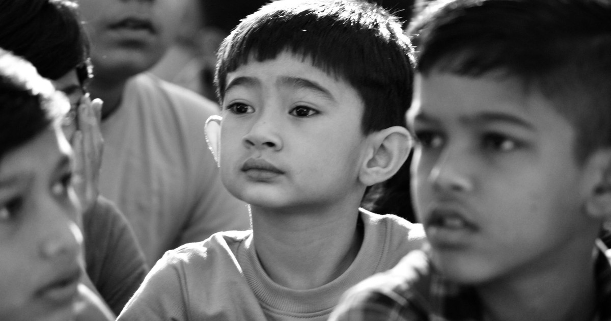 Engaged group of children in a thoughtful moment captured in black and white.
