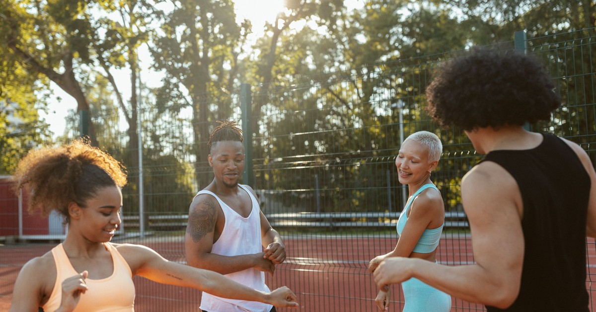 Energetic group of diverse young adults enjoying a game of basketball on a sunny day.