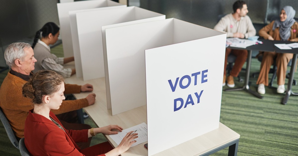 People casting votes in a polling station on election day, emphasizing civic engagement.