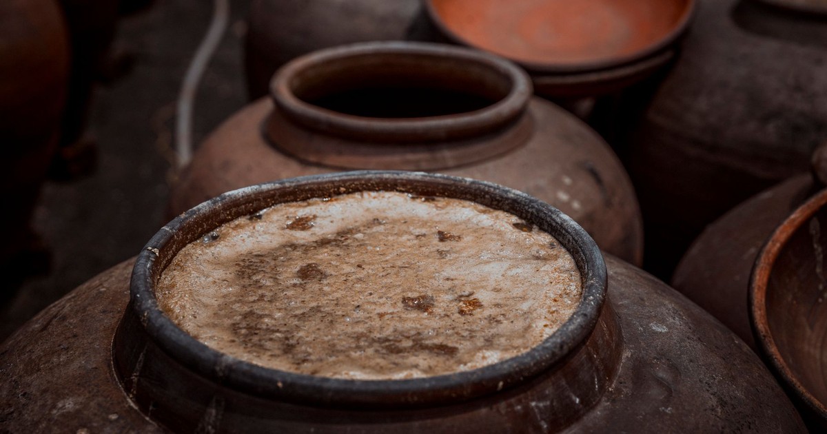 Close-up of rustic ceramic pots with visible fermentation, showcasing traditional pottery techniques.