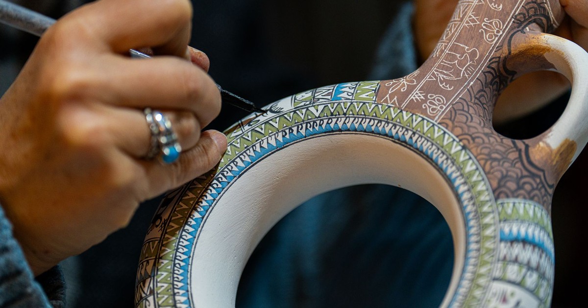 Close-up of an artisan hand-painting a ceramic vessel in Türkiye, showcasing traditional craftsmanship.