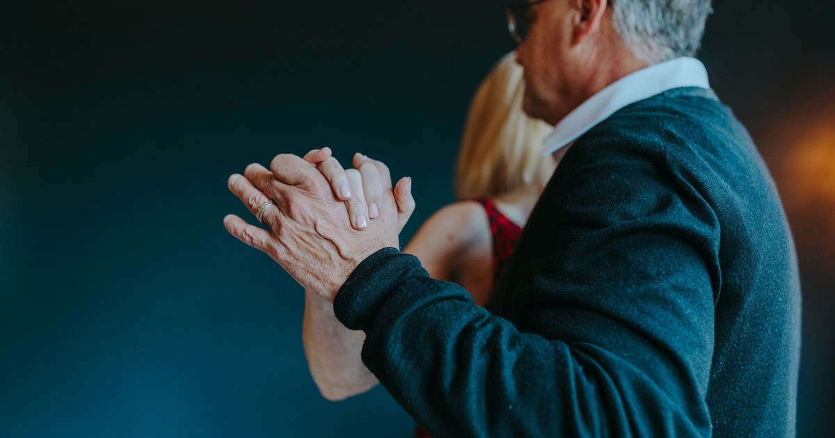 A senior couple gracefully dancing indoors, showcasing love and connection.