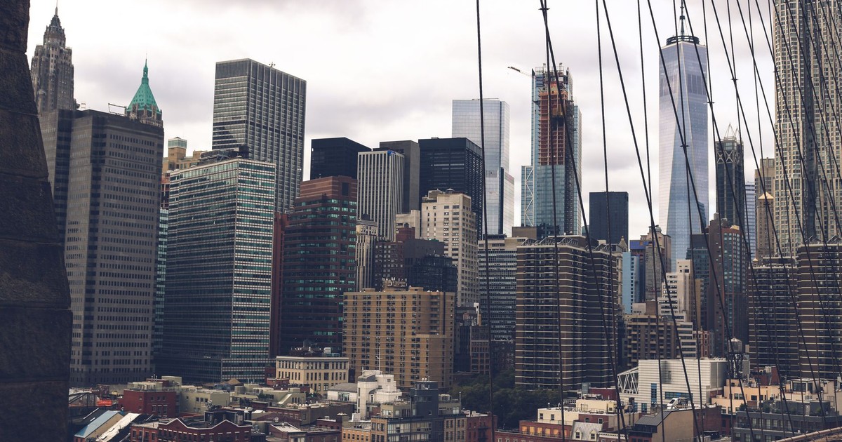 A dramatic view of the skyscrapers of New York City captured from the Brooklyn Bridge.