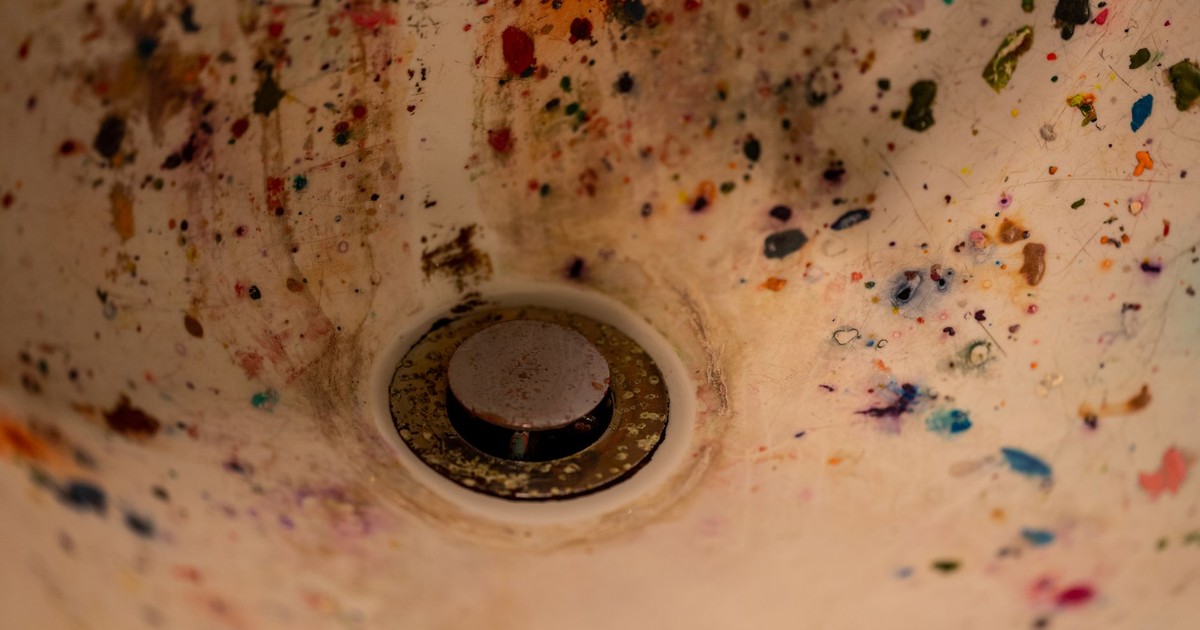 Abstract view of a paint-splattered sink capturing artistic chaos and creativity.