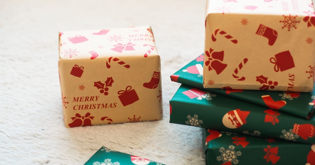 Festively wrapped Christmas gift boxes with patterns of holly, snowflakes, and candy canes.