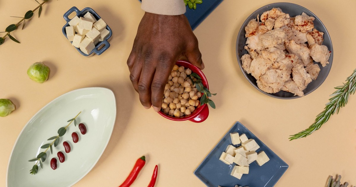 Vibrant flat lay of various vegan ingredients, including chickpeas, tofu, and herbs.