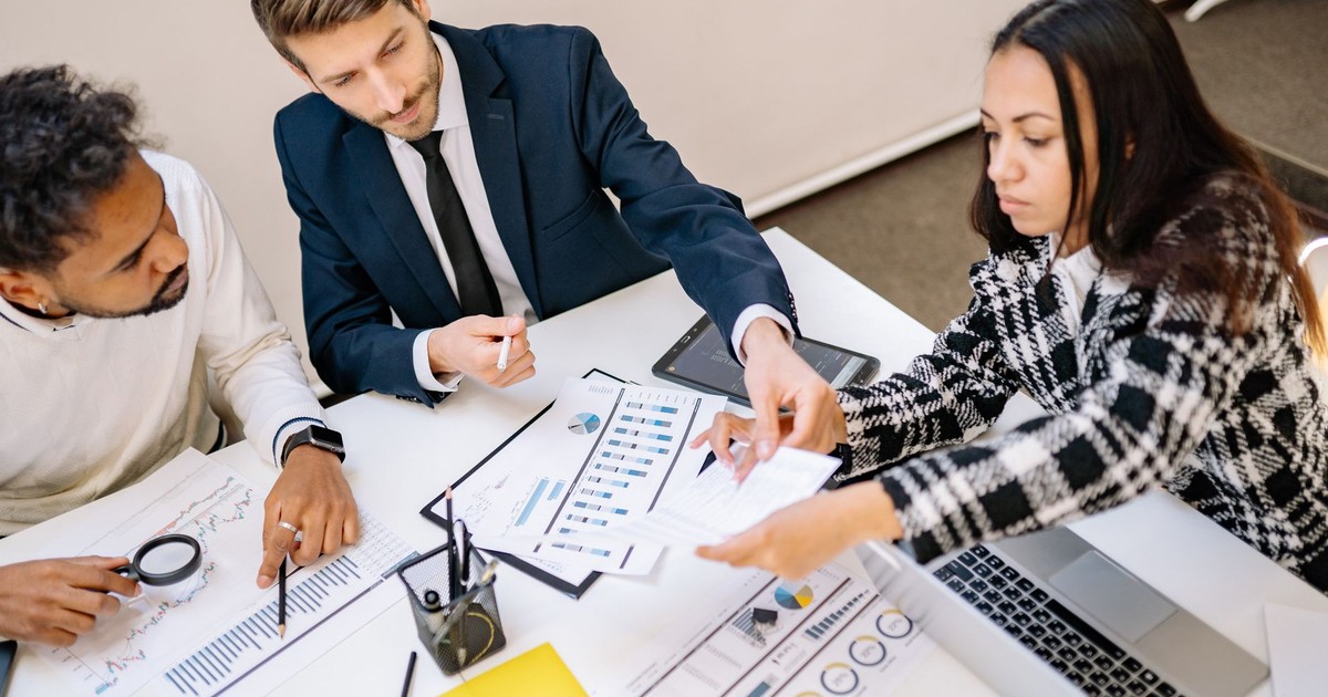 Business professionals engaging in a collaborative meeting with charts and documents.