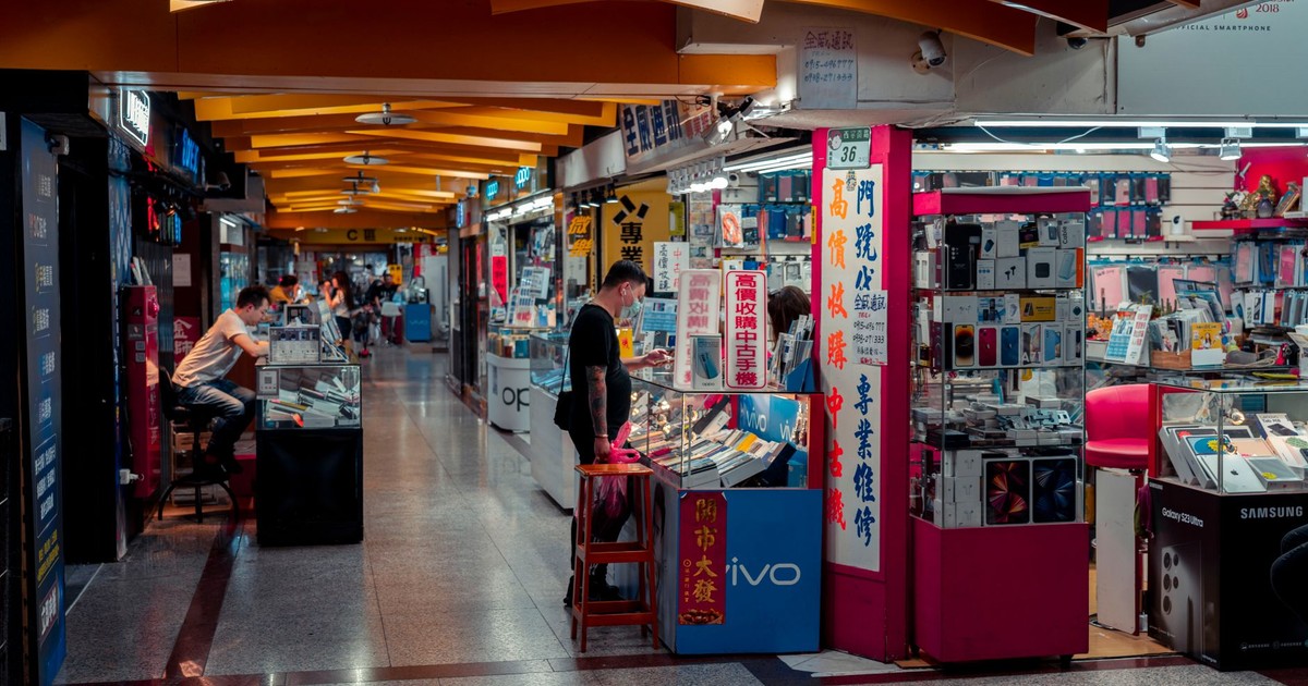 Busy indoor electronics market with modern design and engaged shoppers.