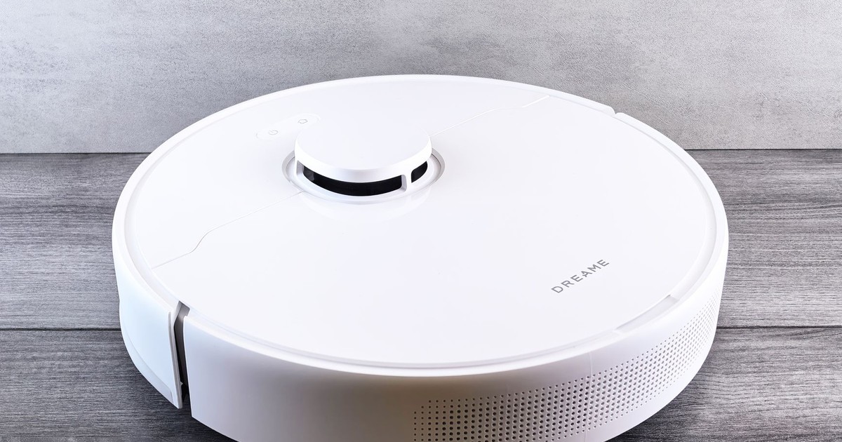 Sleek white robot vacuum cleaner on a wooden floor, perfect for smart home setups.